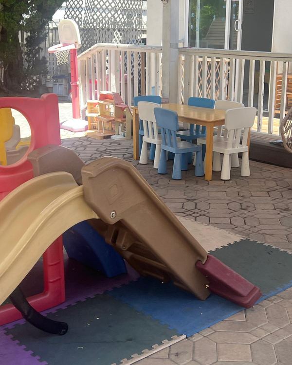 Covered patio with a child-size table, chairs and a slide