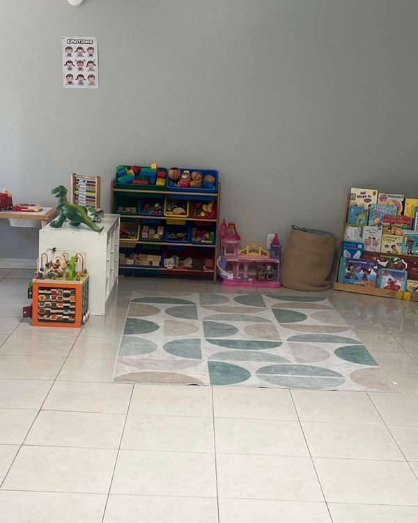 Reading corner with a shelf of picture books and toy bins